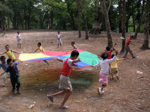 Playing in the park with their new parachute